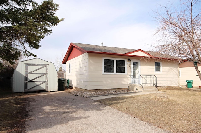 view of front of home featuring an outbuilding, driveway, and a storage unit