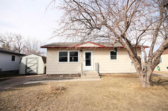 view of front of house featuring an outbuilding, driveway, a storage unit, and entry steps