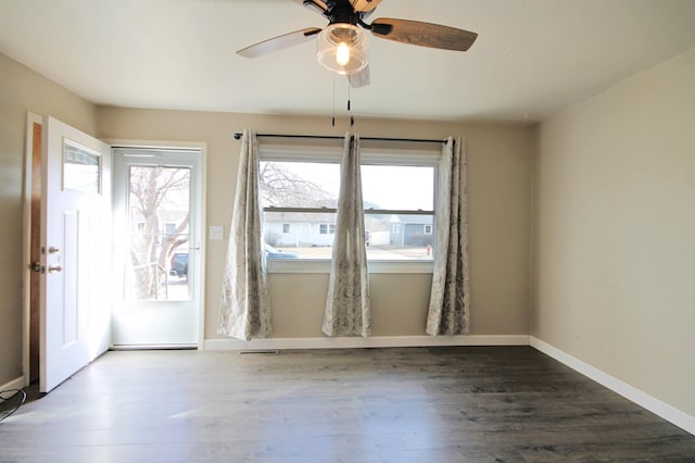 empty room featuring baseboards, a wealth of natural light, and wood finished floors