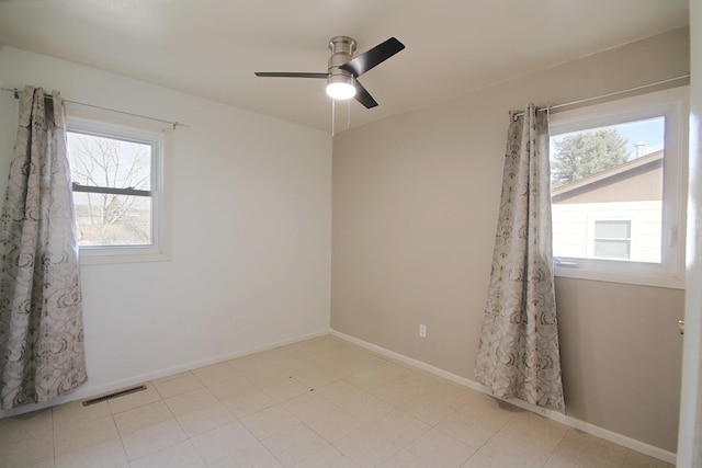 unfurnished room featuring a ceiling fan, visible vents, and baseboards