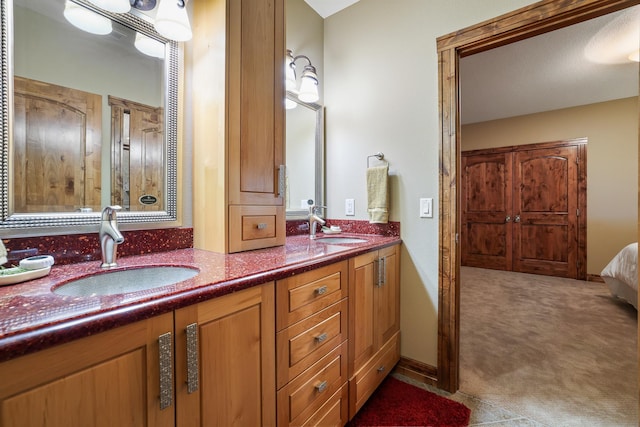 full bath with double vanity, a sink, and baseboards