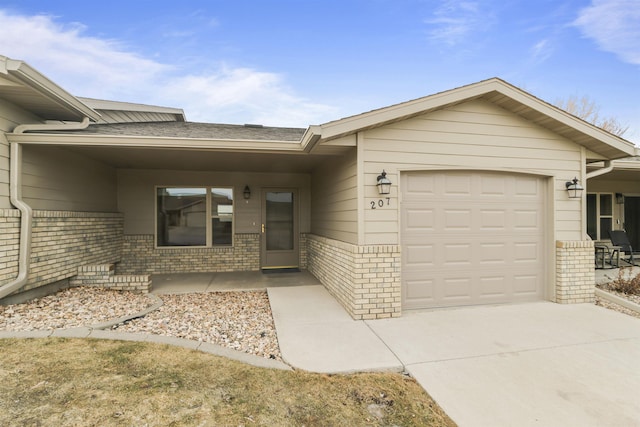 view of front of property with a garage, brick siding, and driveway