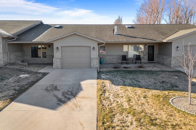 ranch-style home with a garage, concrete driveway, brick siding, and a shingled roof