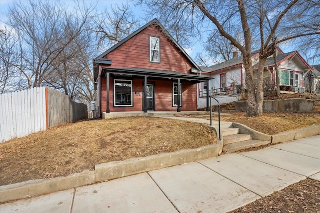 bungalow-style house featuring covered porch and fence