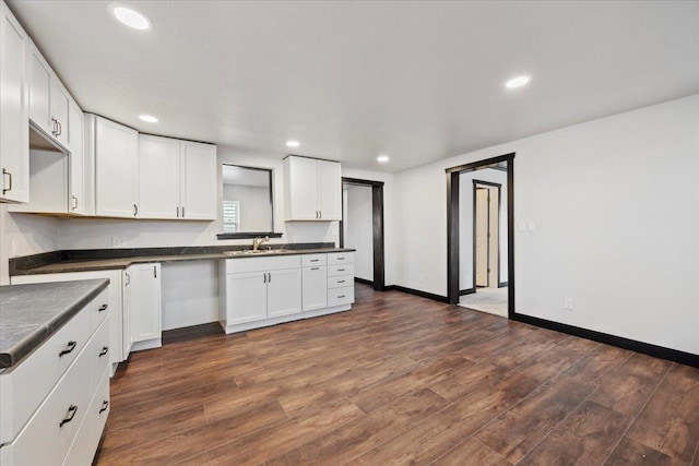 kitchen featuring dark wood-style flooring, dark countertops, and white cabinetry