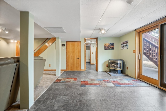 foyer with stairs, a wood stove, a wealth of natural light, and baseboards