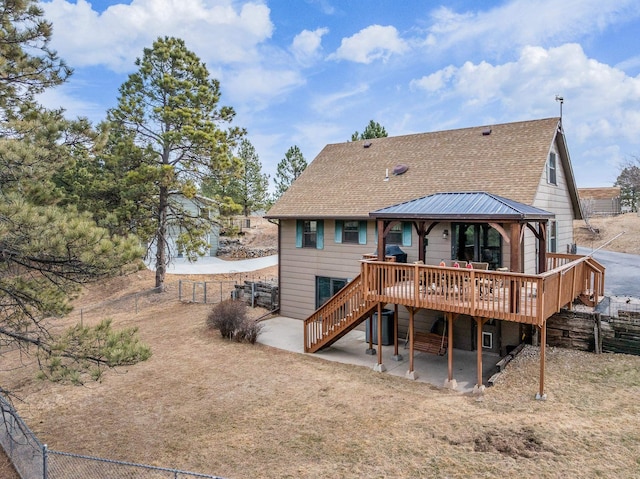 rear view of property with a patio, a wooden deck, a gazebo, and fence