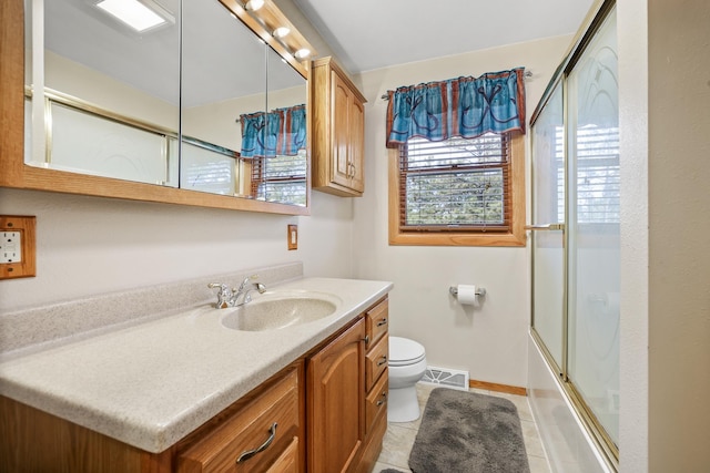 full bathroom featuring shower / bath combination with glass door, visible vents, toilet, vanity, and tile patterned flooring