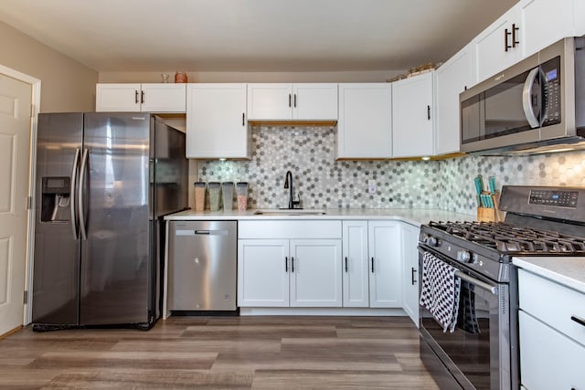 kitchen with stainless steel appliances, backsplash, a sink, and light countertops