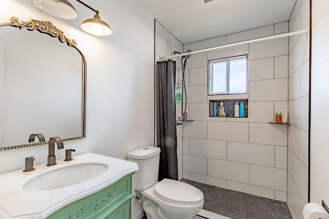 full bathroom with tiled shower, vanity, and toilet