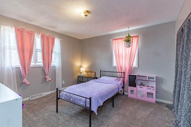 bedroom featuring carpet floors, visible vents, a textured ceiling, and baseboards