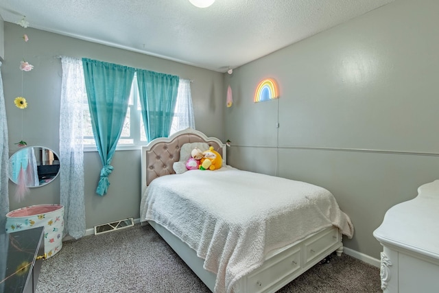 carpeted bedroom featuring a textured ceiling, visible vents, and baseboards