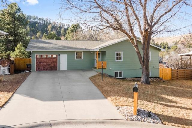 single story home with a garage, concrete driveway, fence, and a gate