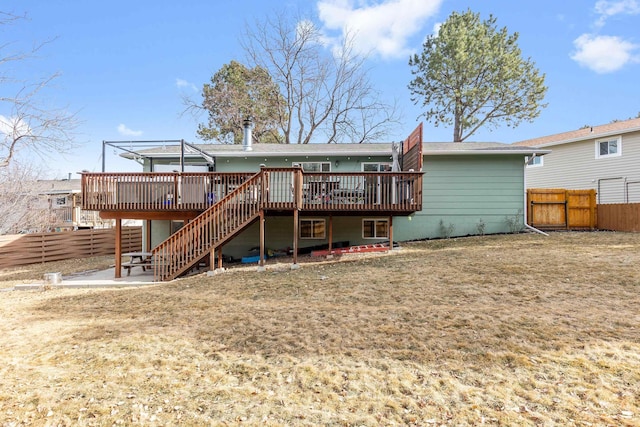 rear view of property featuring fence, a patio, a wooden deck, and stairs