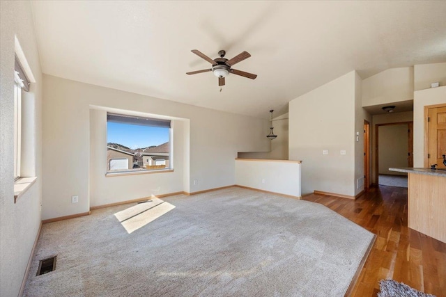 unfurnished living room featuring lofted ceiling, ceiling fan, visible vents, and wood finished floors