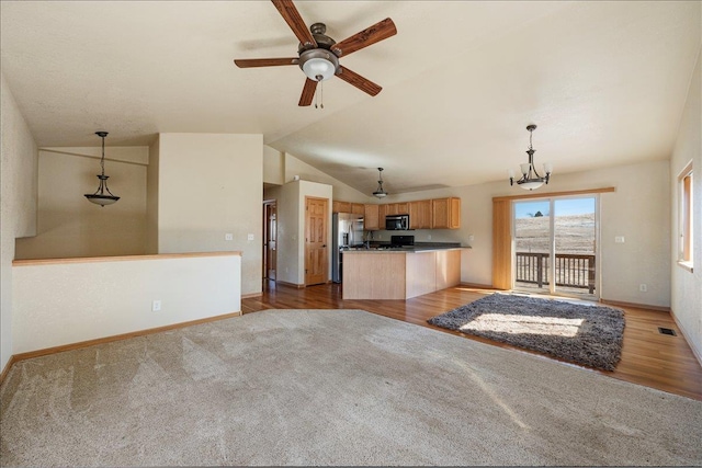 kitchen featuring dark countertops, wood finished floors, visible vents, and decorative light fixtures