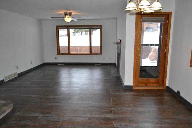 unfurnished room with visible vents, baseboards, and ceiling fan with notable chandelier