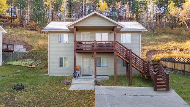 view of front of home with a shingled roof, stairs, fence, and a front lawn