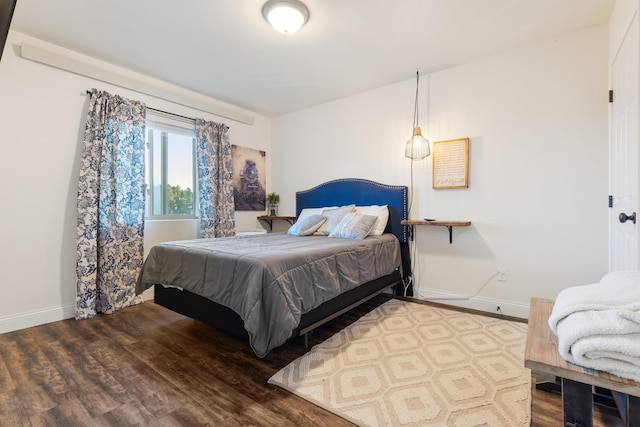 bedroom with baseboards and wood finished floors