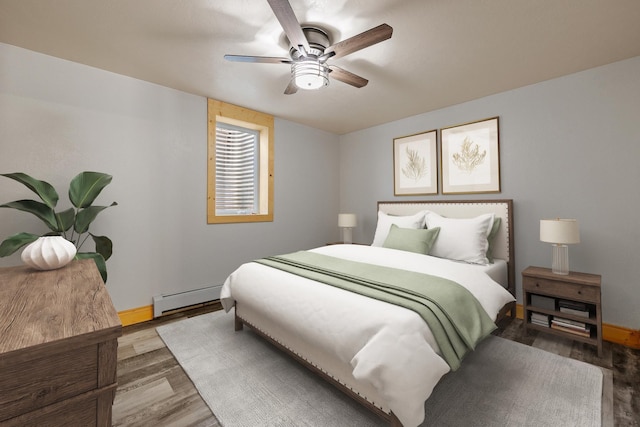 bedroom featuring baseboards, a baseboard heating unit, ceiling fan, and wood finished floors