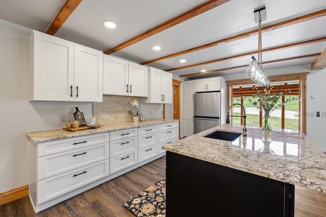 kitchen with beamed ceiling, dark wood-style flooring, a sink, and freestanding refrigerator