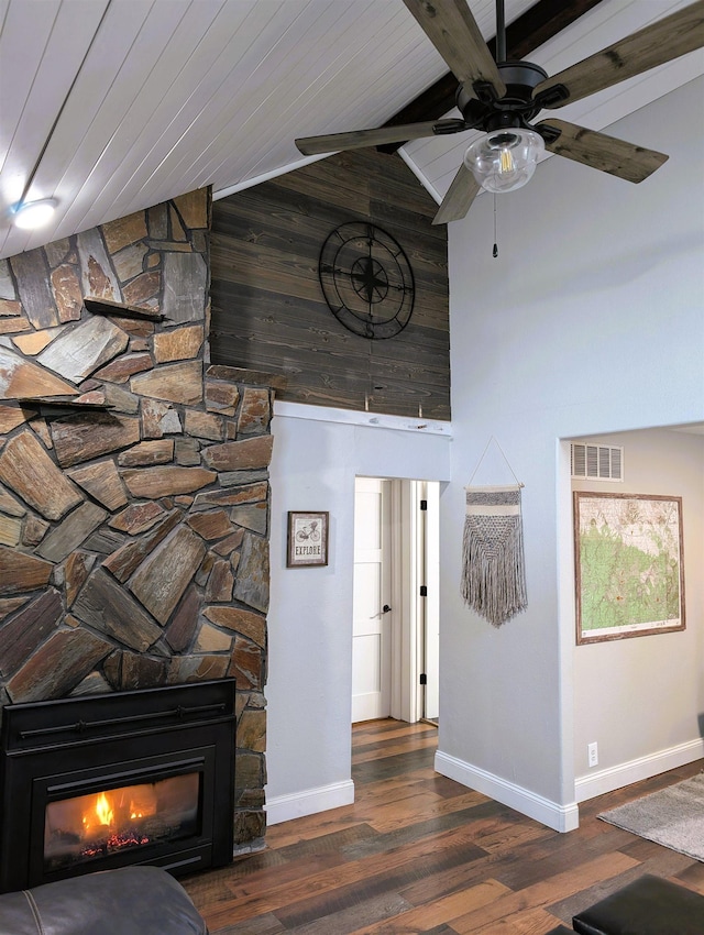 interior space featuring high vaulted ceiling, a fireplace, wood finished floors, visible vents, and baseboards