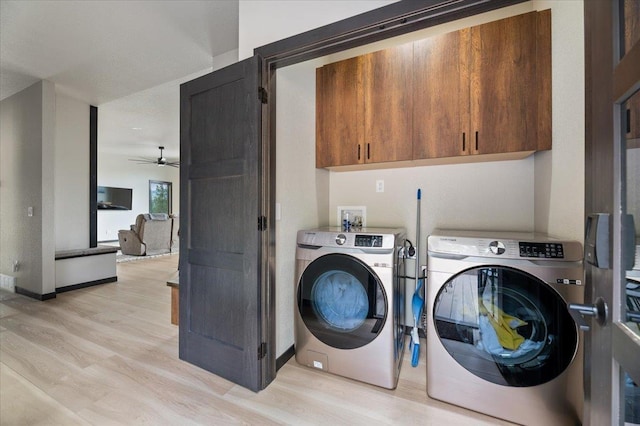 laundry room with light wood-type flooring, cabinet space, washing machine and dryer, and baseboards