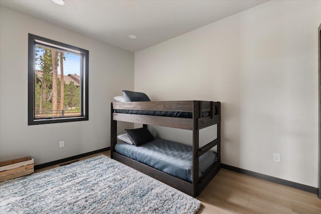 bedroom featuring light wood-style flooring and baseboards