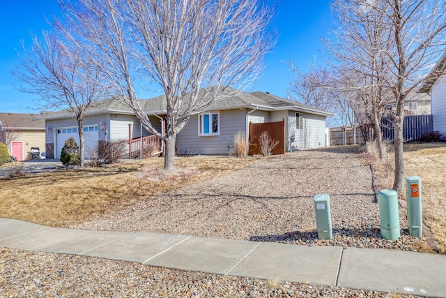 ranch-style house with an attached garage and fence