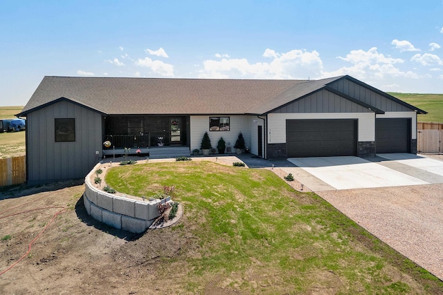 single story home with a garage, concrete driveway, fence, a front lawn, and board and batten siding