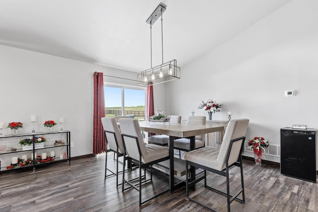 dining space with an inviting chandelier, baseboards, and wood finished floors