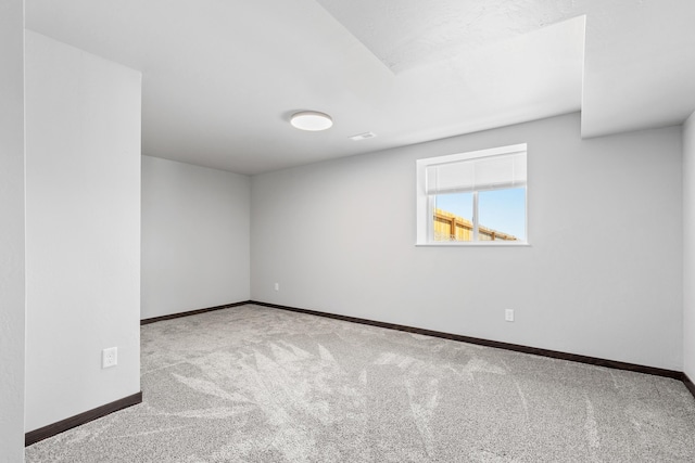 empty room featuring carpet and baseboards