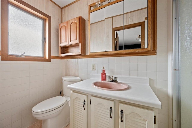 bathroom with ornamental molding, tile walls, vanity, and toilet