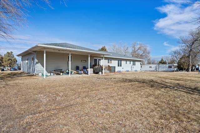 rear view of property featuring a lawn