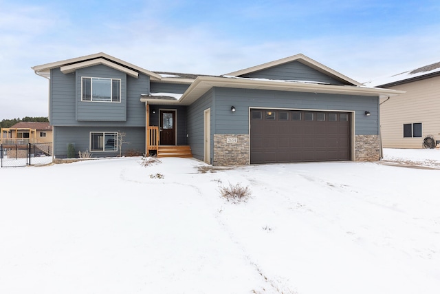 view of front facade with a garage, stone siding, and fence