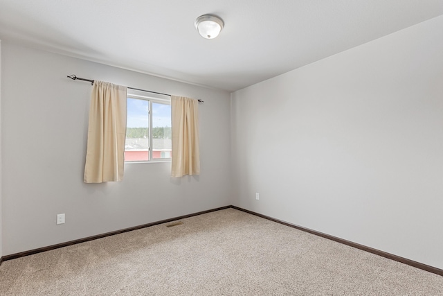 carpeted empty room with visible vents and baseboards