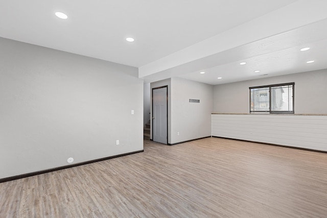 spare room featuring light wood-type flooring, baseboards, and recessed lighting