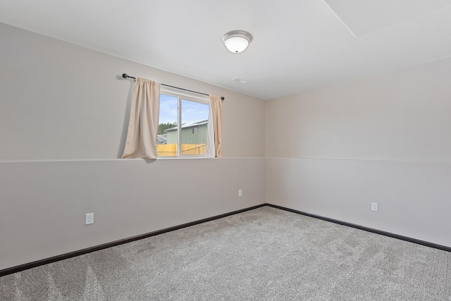 carpeted empty room featuring baseboards