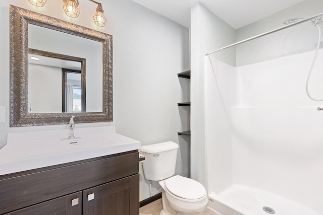 bathroom with a stall shower, vanity, and toilet