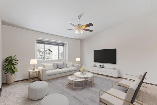 carpeted living room with ceiling fan and baseboards