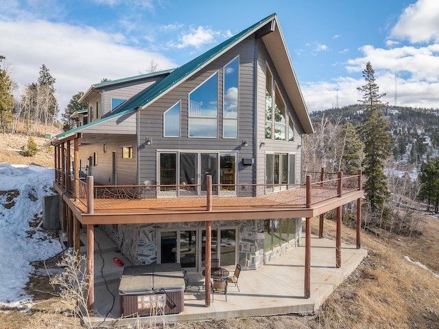 rear view of house featuring a deck and a patio