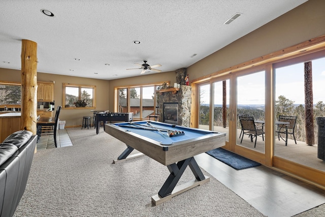 recreation room featuring visible vents, ceiling fan, a stone fireplace, a textured ceiling, and billiards