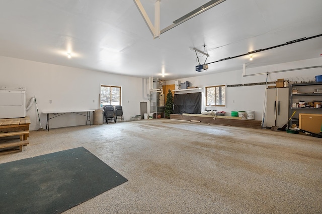 garage featuring independent washer and dryer, freestanding refrigerator, and a garage door opener