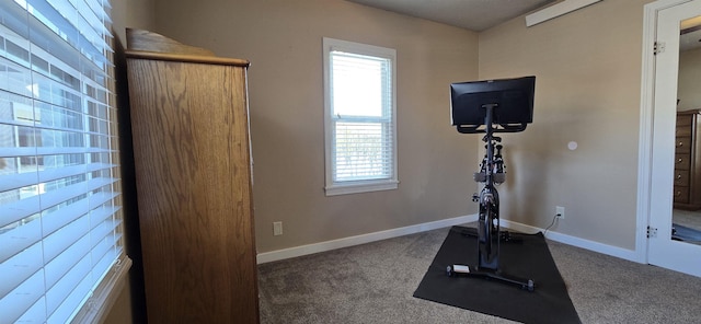 workout room featuring carpet floors and baseboards