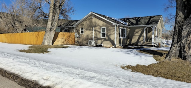 view of snowy exterior featuring fence