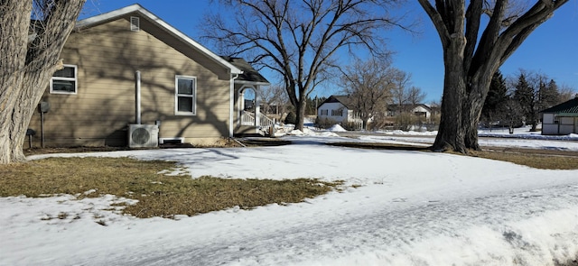 yard layered in snow featuring ac unit