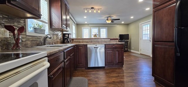 kitchen with a peninsula, dark wood-style flooring, a sink, stainless steel dishwasher, and freestanding refrigerator