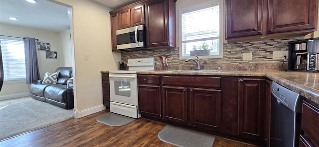 kitchen with appliances with stainless steel finishes, plenty of natural light, a sink, and tasteful backsplash