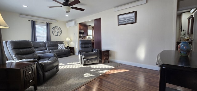 living room featuring baseboards, a ceiling fan, wood finished floors, an AC wall unit, and recessed lighting