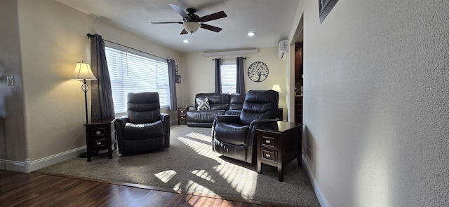 living room featuring ceiling fan, baseboards, wood finished floors, and a textured wall